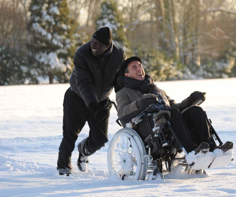 Escena de la película Intouchables, el Asistente Personal da un paseo gracioso a su asistido en la nieve.